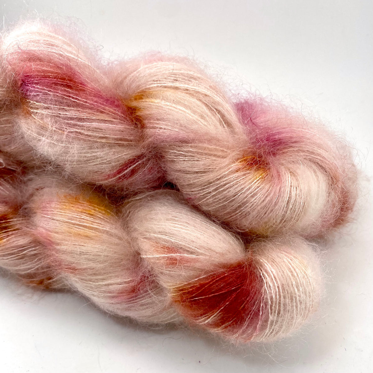 Hand-dyed cotton thick and thin yarn, 525 yard skeins, in shades of red,  pink, beige, and brown